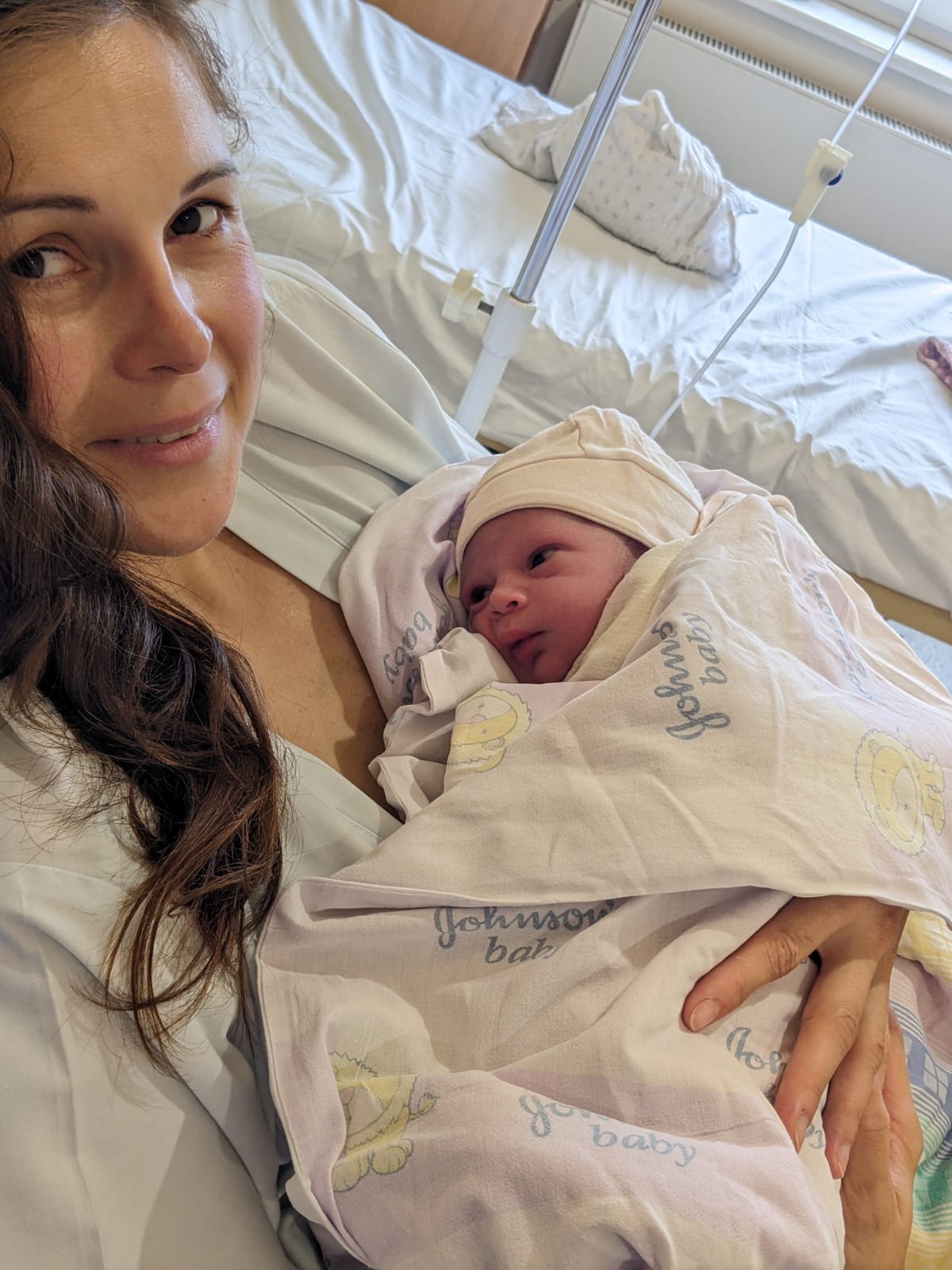 Mother holding her newborn baby in hospital, original photo
