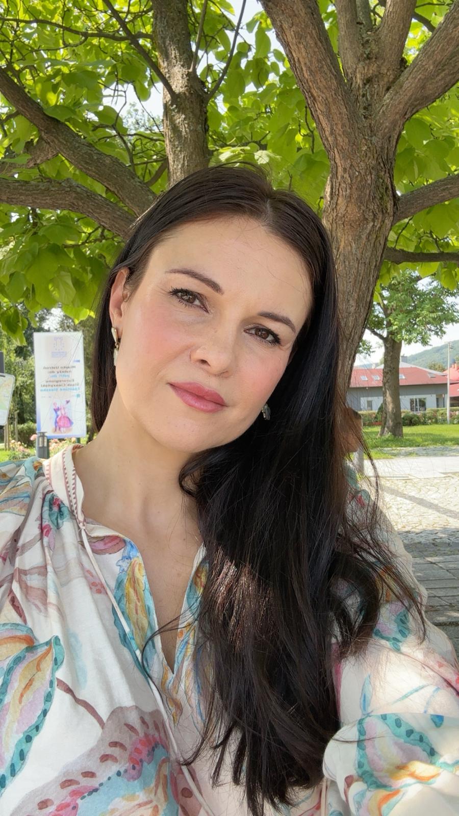 Woman smiling beneath a leafy tree, original photograph